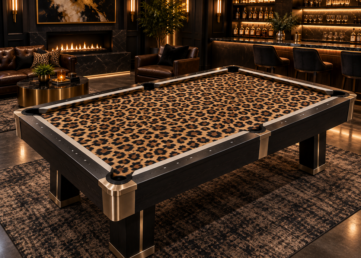Leopard print custom pool table felt on a modern black pool table in a high-end lounge with fireplace, bar seating, and warm ambient lighting.